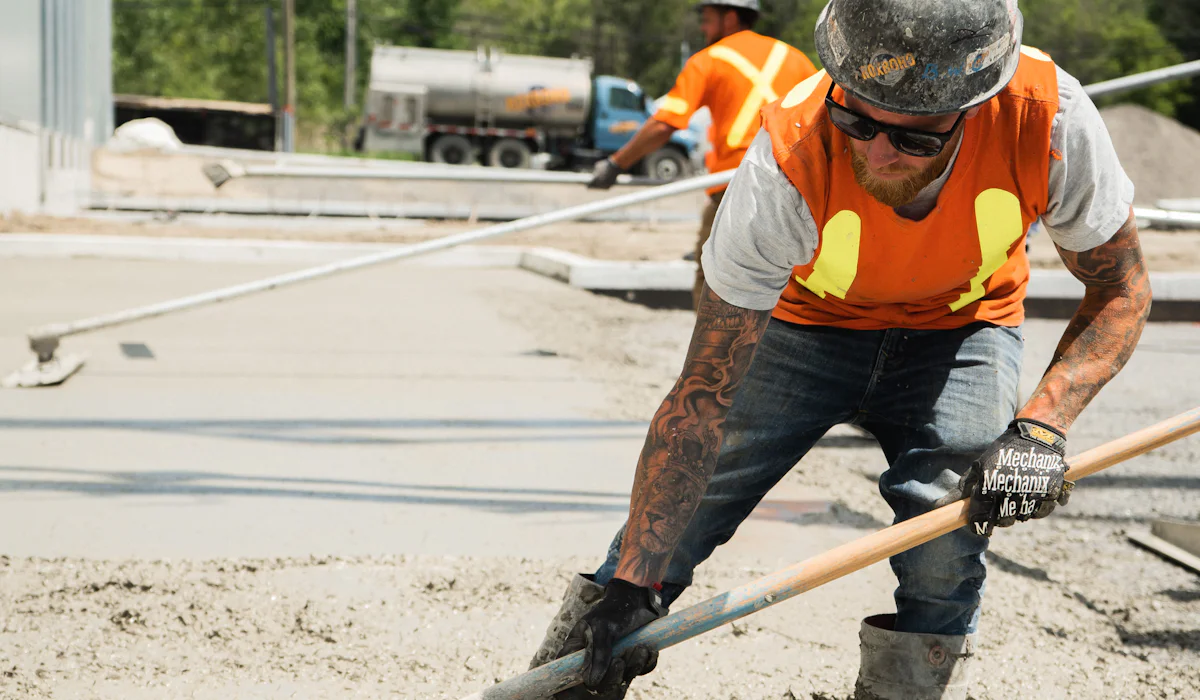 A worker in a high visibility vest working on a concrete surface