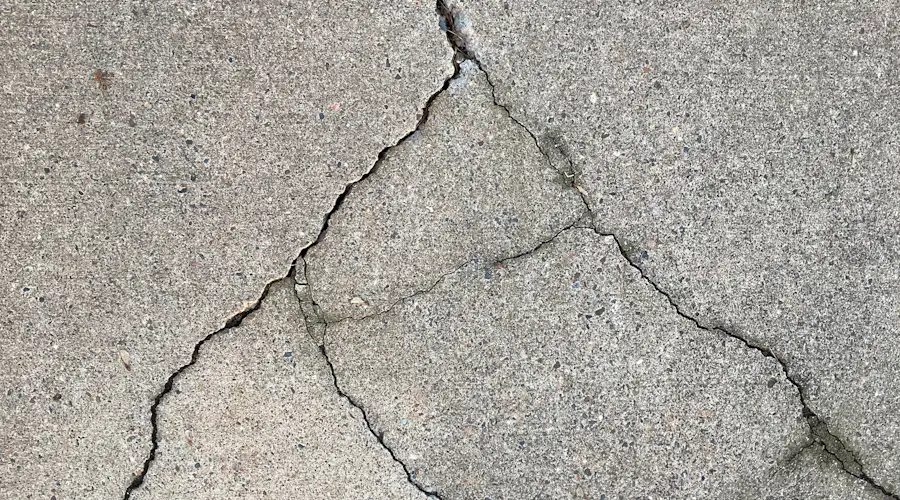 A wide crack running across a concrete surface