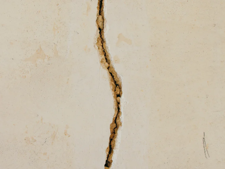 A crack running across a pale concrete surface